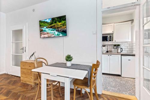 een keuken en eetkamer met een witte tafel en stoelen bij Cosy Studio 10 min Center in Bratislava