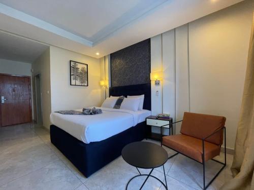 um quarto de hotel com uma cama grande e uma cadeira em Blue Apple Hotel em Lekki