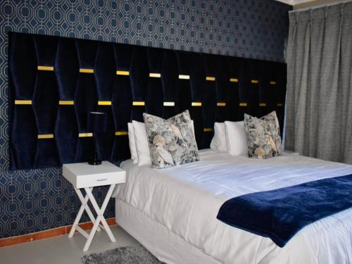 a bedroom with a large bed with a large headboard at Serene Guest Manor in Johannesburg