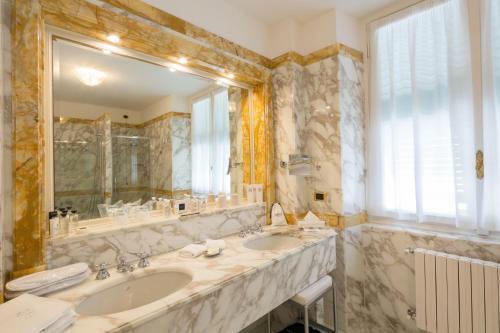 a bathroom with two sinks and a large mirror at Imperiale Palace Hotel in Santa Margherita Ligure