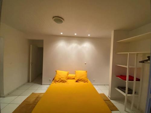 1 cama grande con almohadas amarillas en una habitación en Jolie villa F4 vue mer en Rivière-Salée