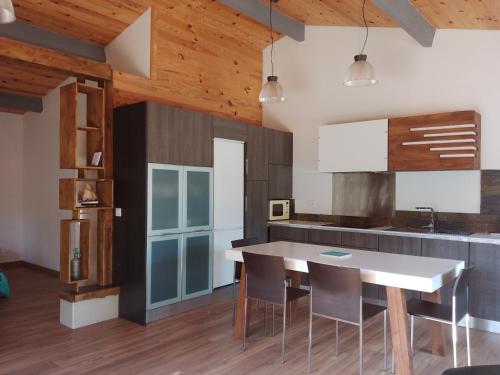 eine Küche mit einem Tisch und Stühlen sowie Holzdecken in der Unterkunft Casa Chélo in Saint-Vincent-de-Tyrosse
