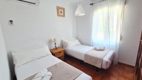 a bedroom with two beds and a window at Nerja Villas Tamango Hill Silhouse in Nerja