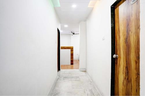 a corridor with a wooden door in a room at Hotel Apollo in Ahmedabad