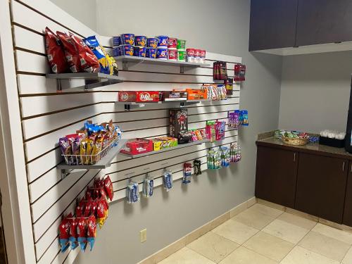 a wall with shelves filled with food and snacks at Burrstone Inn, an Ascend Collection Hotel in Utica
