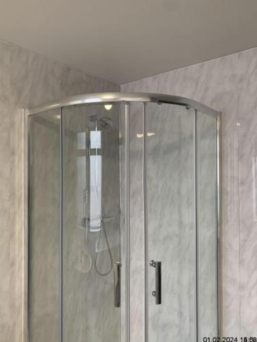 a shower with a glass door in a bathroom at Silcoates Houser in Wakefield