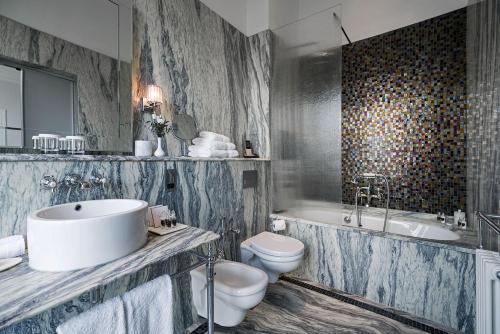 a bathroom with a sink and a tub and a toilet at The Adria in London