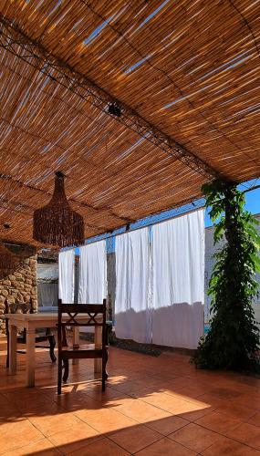 a patio with a table and a bench under a pergola at Las catalinas hospedajes in Chilecito