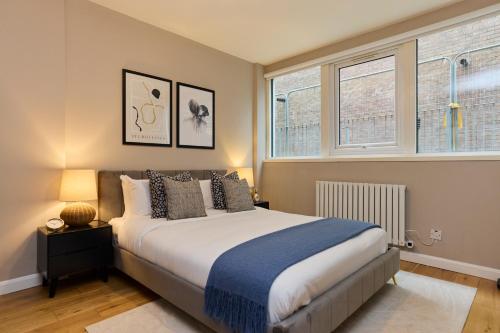 a bedroom with a bed and two windows at The Deptford Hideout - Lovely 1BDR Flat in London