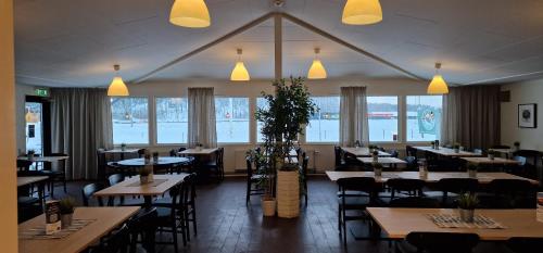 une salle à manger avec des tables, des chaises et des lumières dans l'établissement Rasta Grums, à Grums