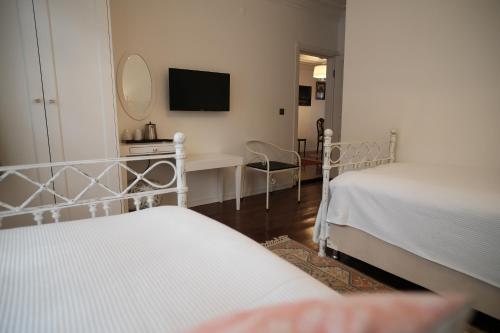 a bedroom with two beds and a desk and a mirror at MECİT KAPTAN KONAĞI in Kastamonu