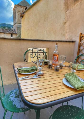 - une table en bois avec une bouteille de vin dans l'établissement Le Petit Delphia, à Apt