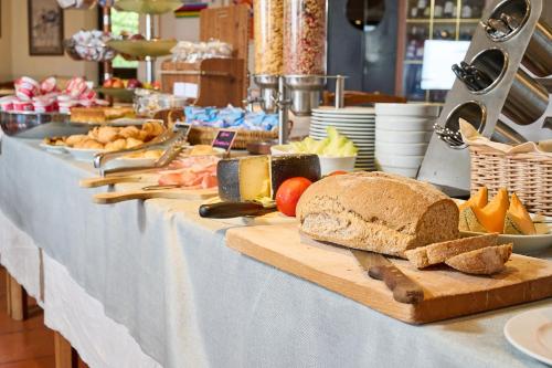 una mesa larga con pan y otros alimentos. en Hotel Zì Martino, en Castagneto Carducci