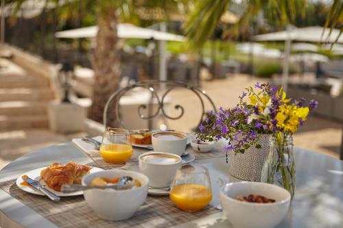 Una mesa cubierta con platos de desayuno y jugo de naranja. en Château St Pierre de Serjac, en Puissalicon