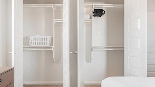 um armário branco com portas e prateleiras brancas em Landing Modern Apartment with Amazing Amenities (ID7008X25) em Bentonville