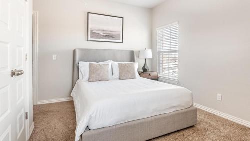 um quarto branco com uma cama e uma janela em Landing Modern Apartment with Amazing Amenities (ID7008X25) em Bentonville