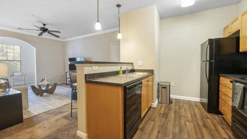 eine Küche mit einer Spüle und einem schwarzen Kühlschrank in der Unterkunft Landing Modern Apartment with Amazing Amenities (ID9830X28) in Greer