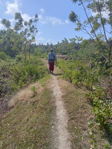un hombre caminando por un camino de tierra en BALE G-SHOQ en Kuta Lombok