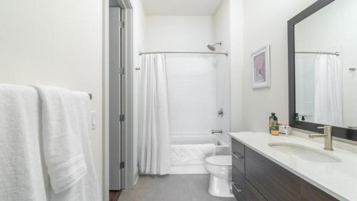 Baño blanco con lavabo y aseo en Landing Modern Apartment with Amazing Amenities (ID2441X04) en Pittsburgh