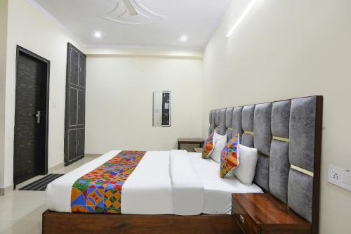 a bedroom with a large bed with a large headboard at FabExpress ASP Royal Residency Inn- Janakpuri in New Delhi