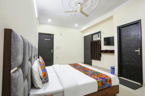 a bedroom with a bed and a ceiling fan at FabExpress ASP Royal Residency Inn- Janakpuri in New Delhi