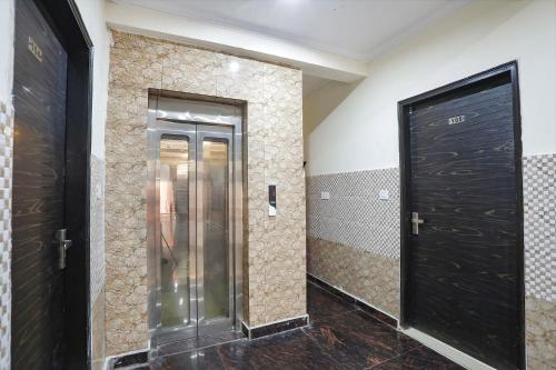 a corridor with two black doors in a room at FabExpress ASP Royal Residency Inn- Janakpuri in New Delhi