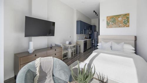 ein Schlafzimmer mit einem Bett und einem TV an der Wand in der Unterkunft Landing - Modern Apartment with Amazing Amenities (ID1401X749) in Nashville