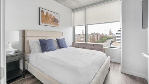 een witte slaapkamer met een bed en een raam bij Landing - Modern Apartment with Amazing Amenities (ID1401X750) in Nashville