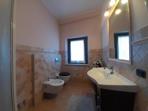 a bathroom with a sink and a toilet and a mirror at Casal dei Colli in Amelia