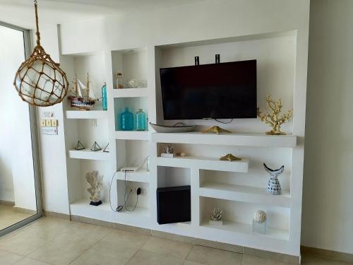 salon z telewizorem na białej ścianie w obiekcie Vista marina Marbella w mieście Juan Pedro