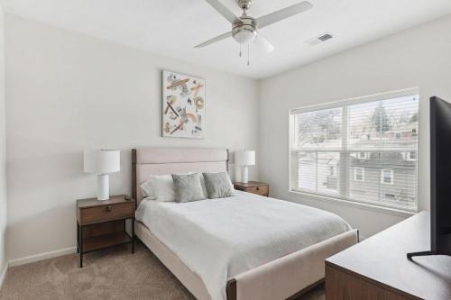 ein weißes Schlafzimmer mit einem Bett und einem Fenster in der Unterkunft Landing Modern Apartment with Amazing Amenities (ID7435X07) in Omaha