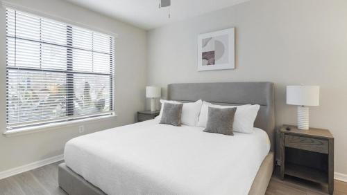 Un dormitorio blanco con una cama grande y una ventana en Landing Modern Apartment with Amazing Amenities (ID9801X81) en Tampa