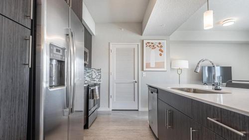 uma cozinha com um frigorífico de aço inoxidável e um lavatório em Landing Modern Apartment with Amazing Amenities (ID8083X57) em Fort Myers Villas