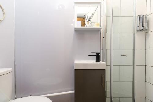 a bathroom with a sink and a toilet and a shower at Modern abode with Free Parking and Smart TV in Bedworth, Near M6 & George Eliot Hospital in Bedworth