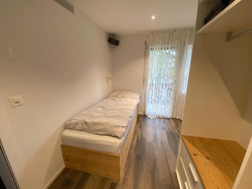 a small room with a bed and a window at Kusi's Ranch in Saas-Fee