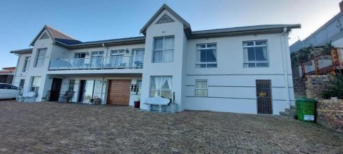a white house with a driveway in front of it at Albatros Nes 49 Van Spilberg Road Saldanha in Saldanha