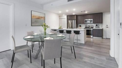a kitchen and dining room with a glass table and chairs at Landing Modern Apartment with Amazing Amenities (ID3378X75) in Pompano Beach