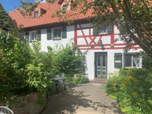 a white and red house with a table and chairs at Ferienhof Klein in Gunzenhausen