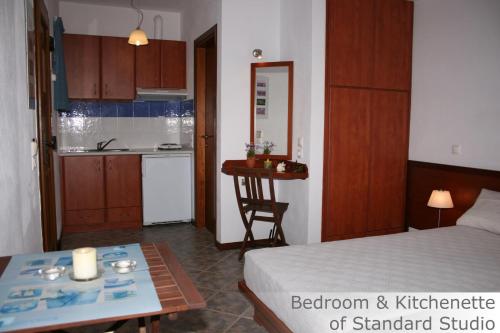 ein Schlafzimmer und eine Küche mit einem Bett und einem Tisch in der Unterkunft Eye Q Resort in Megali Ammos