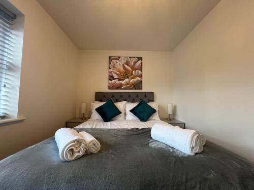 ein Schlafzimmer mit einem großen Bett mit Handtüchern darauf in der Unterkunft Braid House in Loughborough