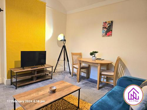 a living room with a tv and a table at The Clevedon Bungalow , Close to Sea Front, Great Locataion in Weston-super-Mare