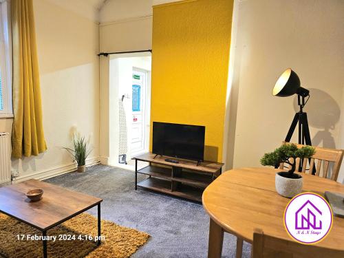 a living room with a tv and a table at The Clevedon Bungalow , Close to Sea Front, Great Locataion in Weston-super-Mare