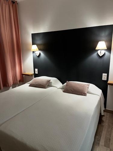 two beds in a bedroom with a black wall at Maison N°133 in Saint-Rémy-de-Provence