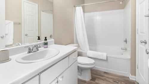 Baño blanco con lavabo y aseo en Landing Modern Apartment with Amazing Amenities (ID1402X064), en Slidell