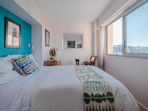 une chambre avec un grand lit et une grande fenêtre dans l'établissement Eiffel Tower Design residence, à Paris
