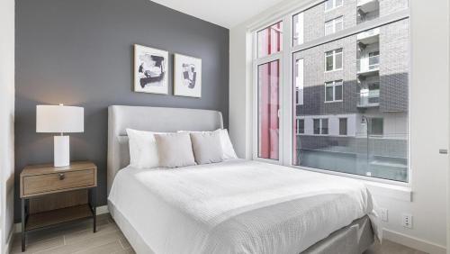 um quarto branco com uma cama e uma janela em Landing Modern Apartment with Amazing Amenities (ID8566X33) em Vancouver