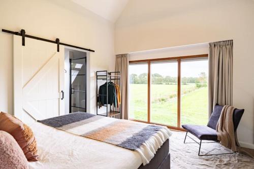 Un dormitorio con una cama grande y una ventana en Het Landzicht, 