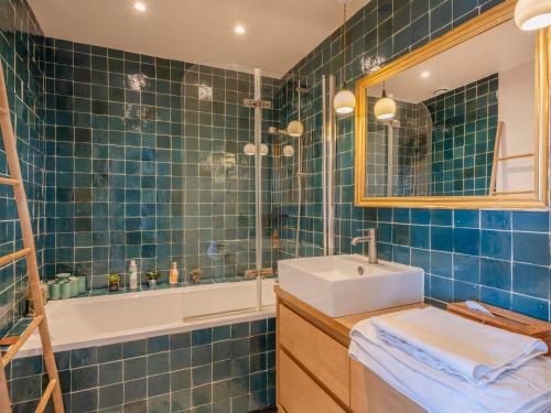 une salle de bain carrelée bleue avec un lavabo et une baignoire dans l'établissement Eiffel Tower Design residence, à Paris