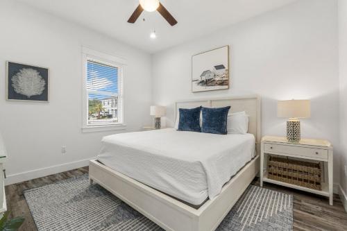 a white bedroom with a bed and a window at The Sand Emperor With Heated Pool And Game Room in Destin