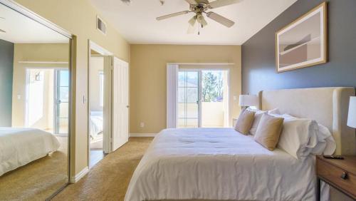 een slaapkamer met een groot wit bed en een spiegel bij Landing Modern Apartment with Amazing Amenities (ID7986X55) in Rancho Cucamonga
